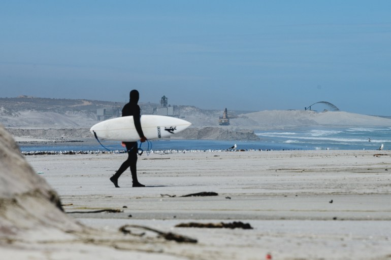 Surfer and PTWC founder Mike Schlebach in front of a coastal mine [Courtesy of Protect the West Coast]