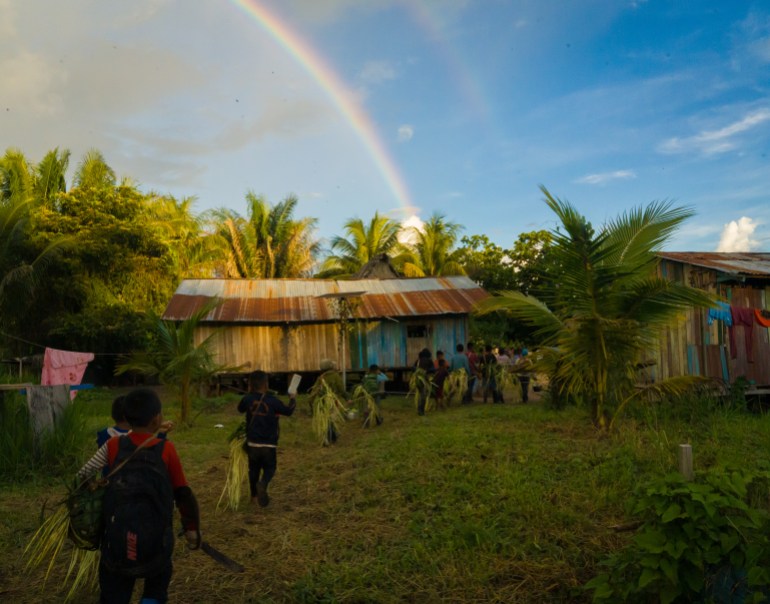 Huni Kuin children in the remote village of Balta carry bush meat from a recent hunt. Their village is a flashpoint of recent contact with isolated tribes in Peru’s eastern Amazon [Neil Giardino/Al Jazeera]