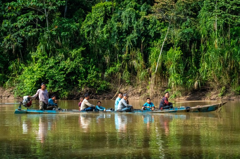 Huni Kuin men and boys ride upriver on a communal hunt [Neil Giardino/Al Jazeera]