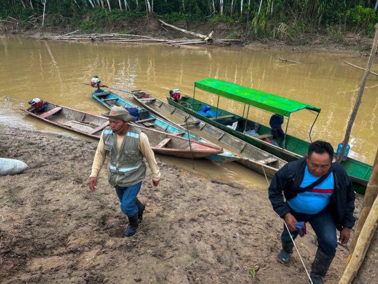 Protection agents Fredy Capitan (left) and Nolasco Torres arrive in Nueva Vida, where sightings of isolated tribes have caused villagers to flee [Neil Giardino/Al Jazeera]