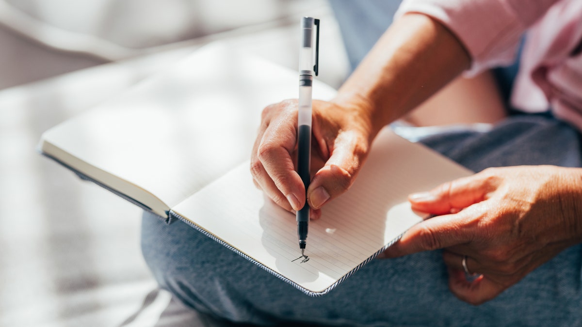 A person writing in journal 