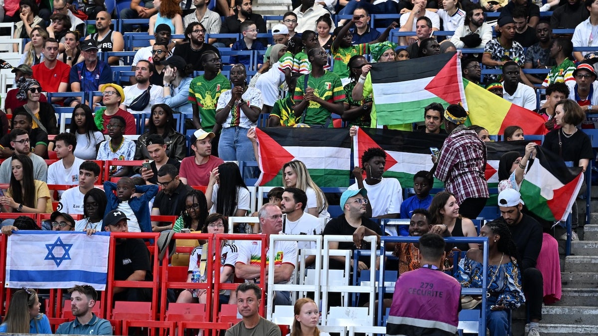 Fans open Palestinian flags during the Men's group D match between Mali and Israel during the Paris 2024 Olympic Games at Parc des Princes stadium in Paris, France on July 24, 2024. 