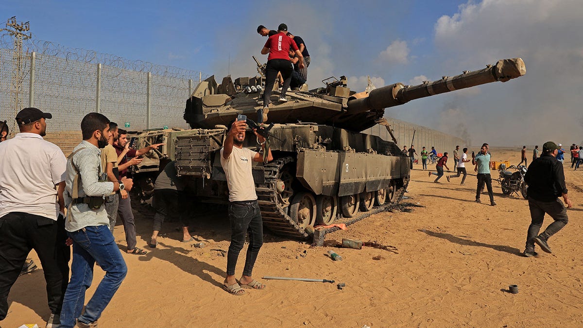 Palestinians near an Israeli tank