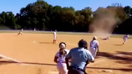 Virginia softball player contends with dust devil as she makes diving play for out