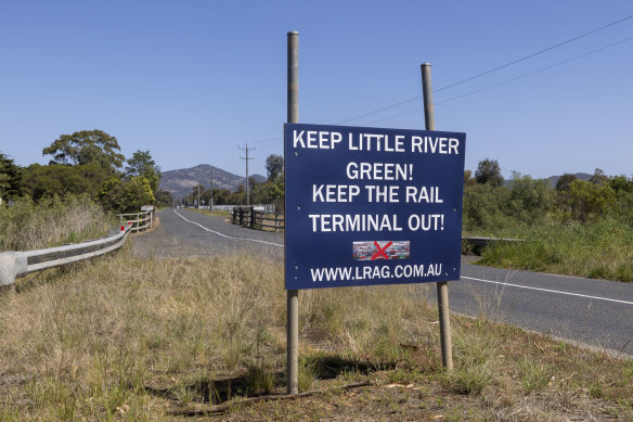 A protest sign stands at the entrance to the town.