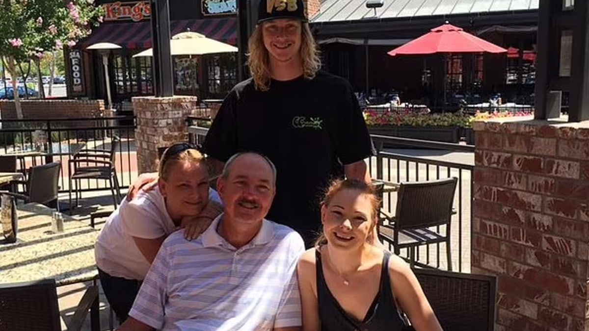 Andreas, Crystal, Michael and Taylor Probst pose outdoors for a family photo.