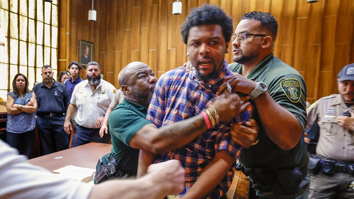 Adrian Cosby restrained in court