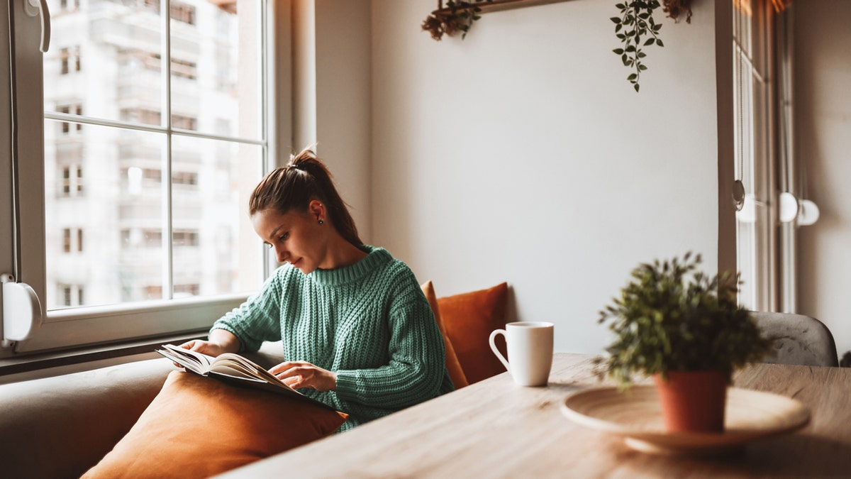 A woman reading a book at home