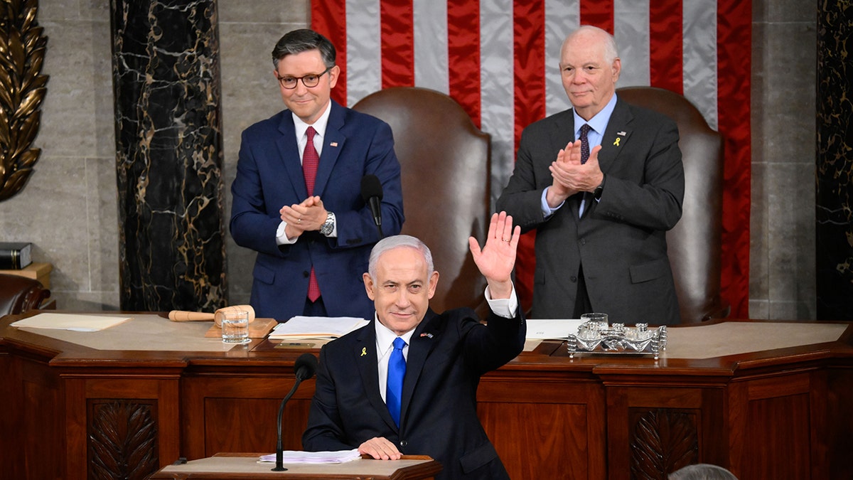 Netanyahu waving to Congress as Speaker Johnson, Sen. Cardin look on