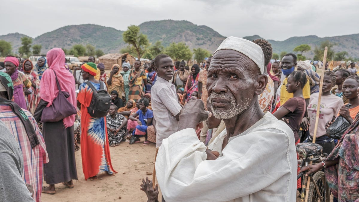 A crowd of people wait to receive food cards at the Agiri internal displacement camp, one of the first camps to open in the Nuba Mountains. June 2024.