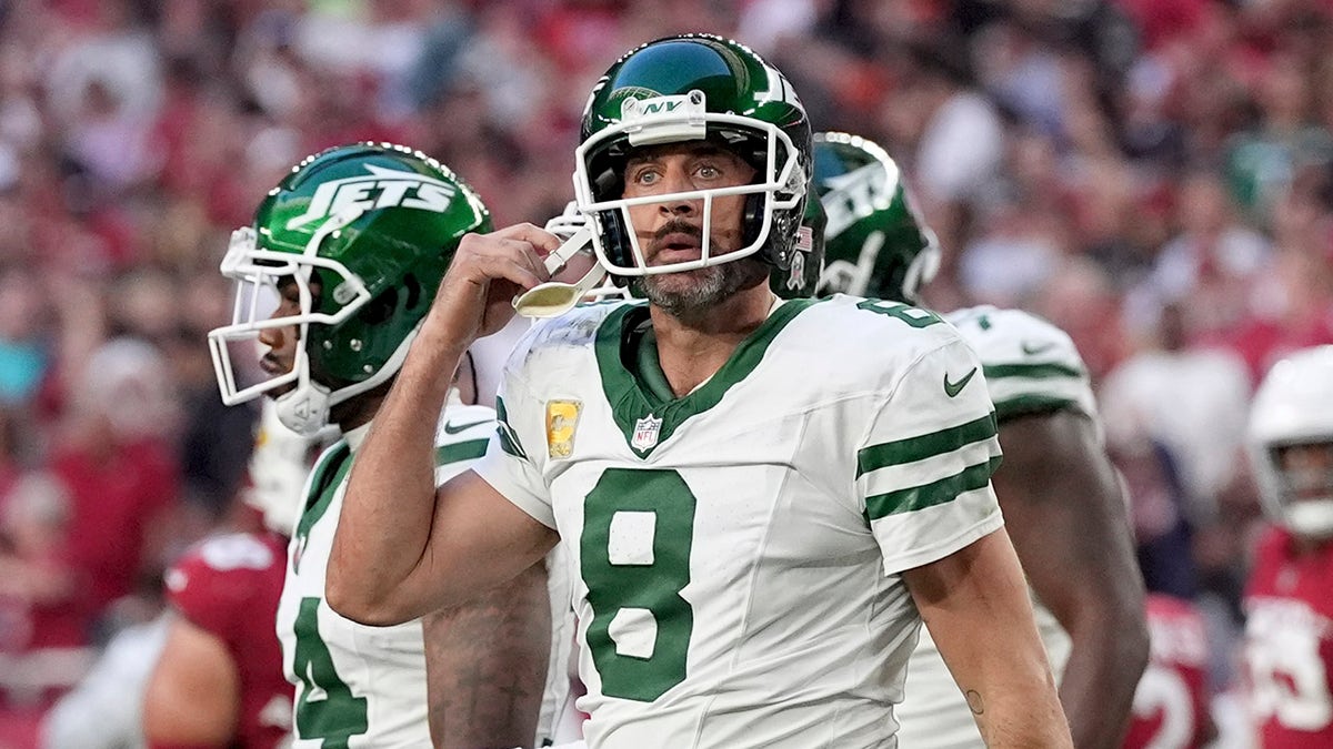 Aaron Rodgers adjusts his helmet