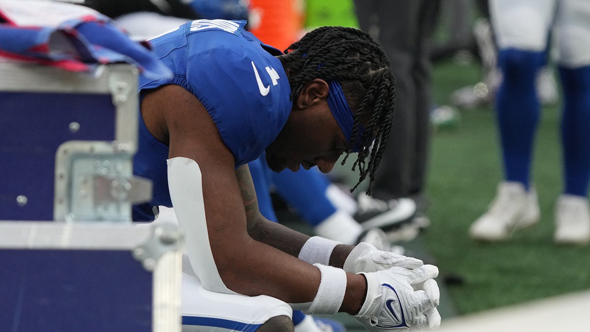 Malik Nabers with head down on sideline