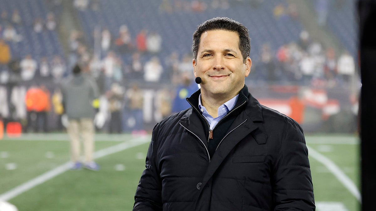 Adam Schefter smiles at podium