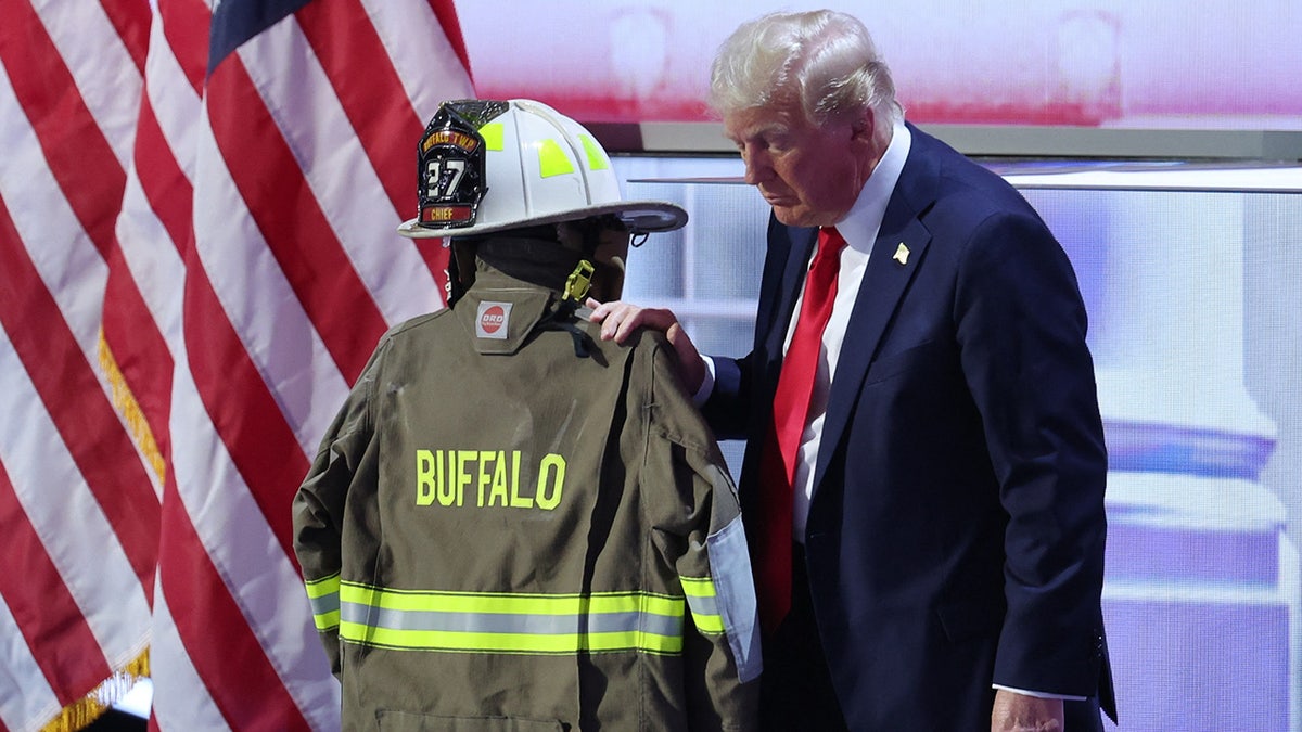 Donald Trump touches the turnout coat of former Buffalo Township Volunteer Fire Department chief Corey Comperatore