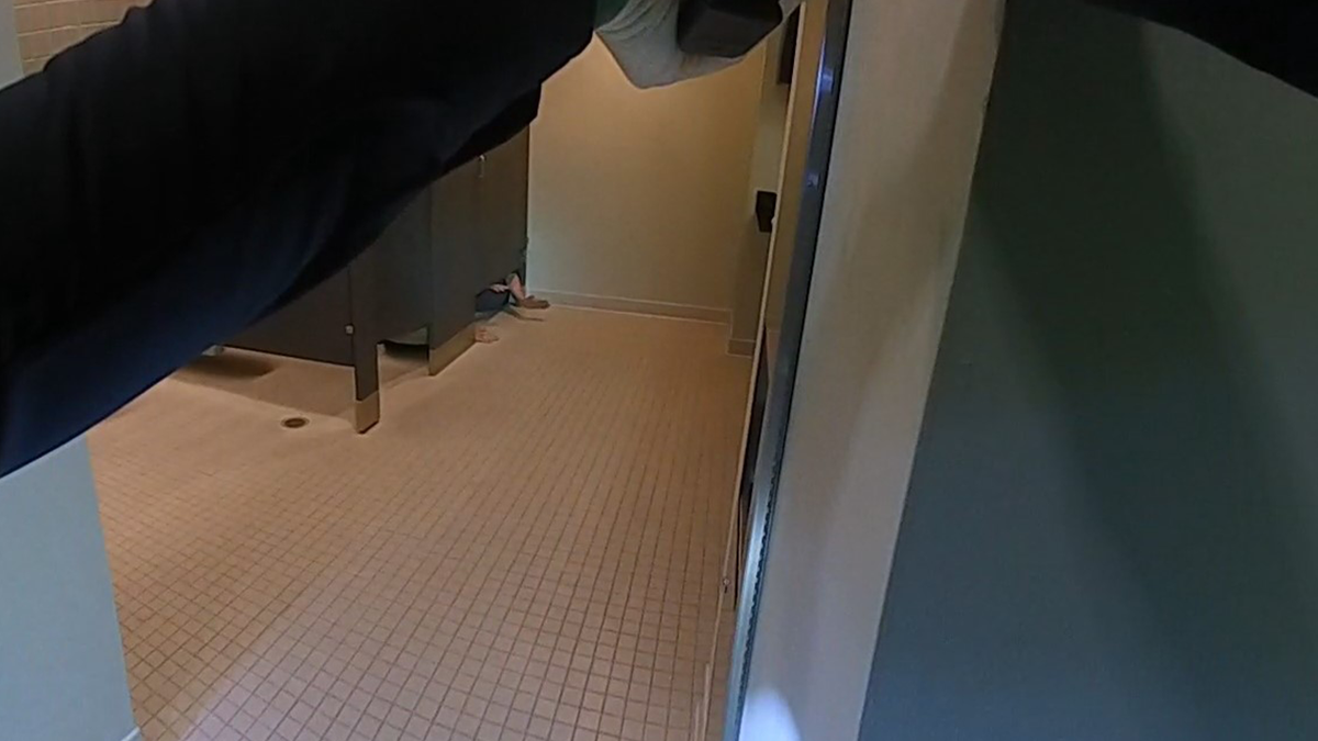 Men hiding in bathroom stall