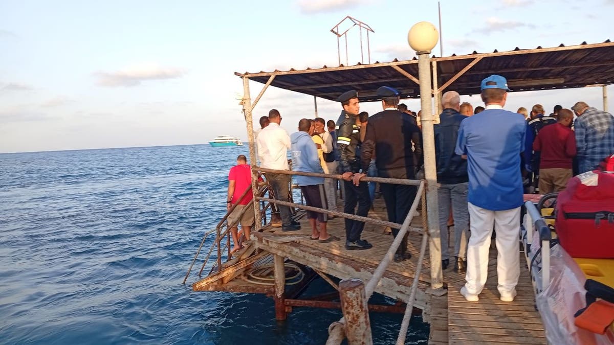 People standing on dock near sinking