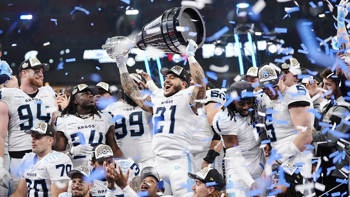 Daniel Adeboboye lifts the Grey Cup