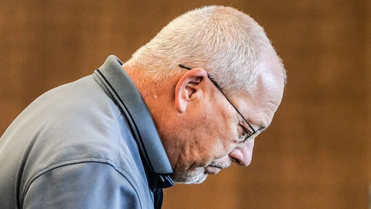 Jeff Jellison looking down to the side wearing a blue collared shirt.