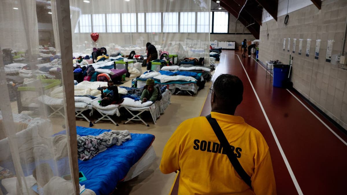 Meshach Little of Northill Wilkston Security Firm walks the perimeter of the main living area at the state's new emergency overflow shelter for migrants at the Melnea A. Cass Recreational Complex. (Photo by Craig F. Walker/The Boston Globe via Getty Images)