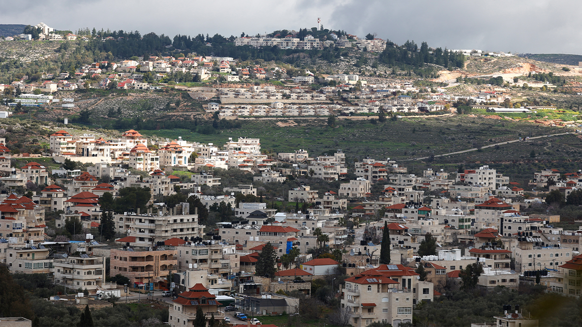 A picture taken in the village of Turmus Ayya near Ramallah city shows the nearby Israeli Shilo settlement in the background, in the occupied West Bank on February 18, 2024.