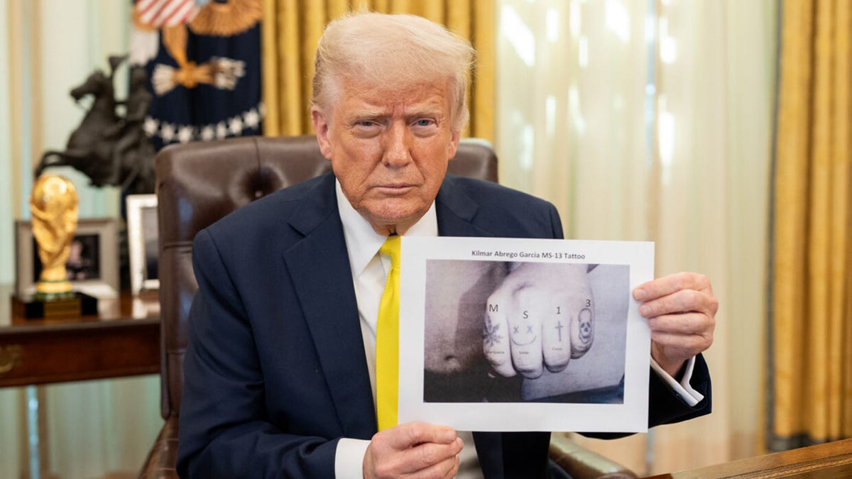 Trump holds up photo of Abrego Garcia's tattoos