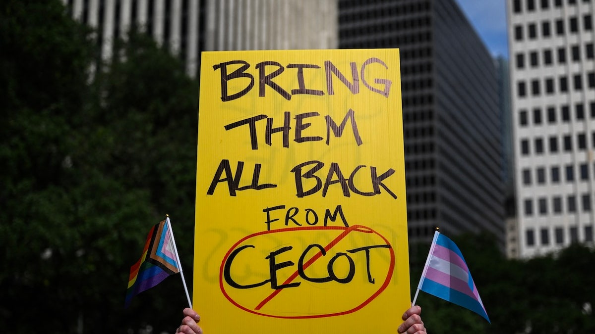 A person holds up a sign referencing the Centre for Terrorism Confinement prison in El Salvador during a May Day demonstration against President Donald Trump and his immigration policies in Houston on May 1, 2025.