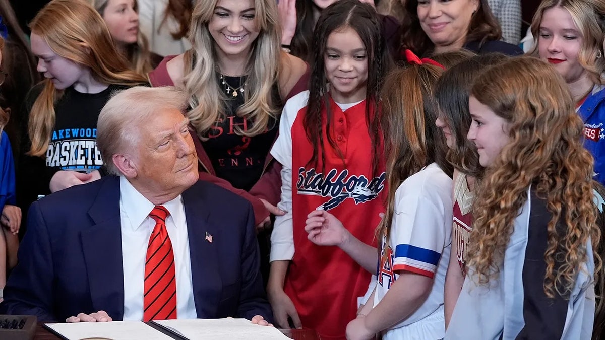 Trump signs executive order, as young female athletes watch, banning transgender women from competing in women's and girls' sporting events on Feb. 6, 2025 at the White House.