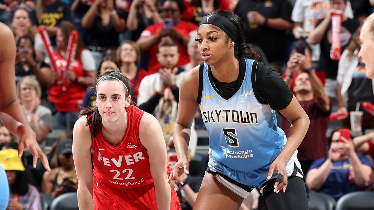 Caitlin Clark, #22 of the Indiana Fever, and Angel Reese, #5 of the Chicago Sky, look on during the game on June 1, 2024, at Gainbridge Fieldhouse in Indianapolis, Indiana.