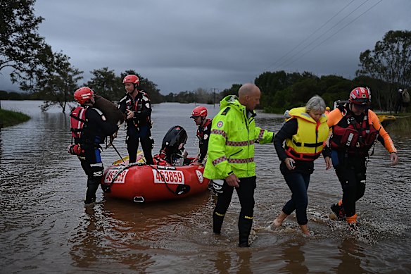 Robyn Doust and her dog Gypsy being rescued by members of NSW Fire & Rescue and the SES in Purfleet, near Taree, on Wednesday.