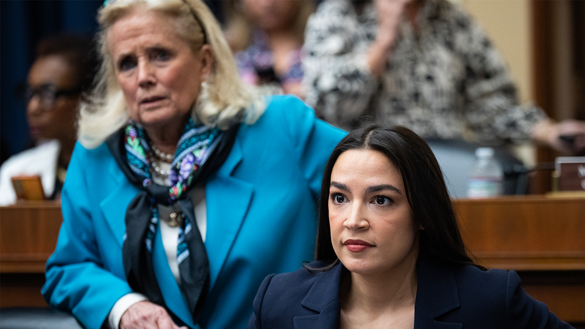 AOC, seated with Debbie Dingell to her right