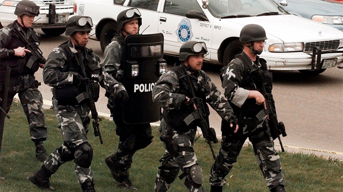 Members of a police SWAT team march to Columbine High School on April 20, 1999