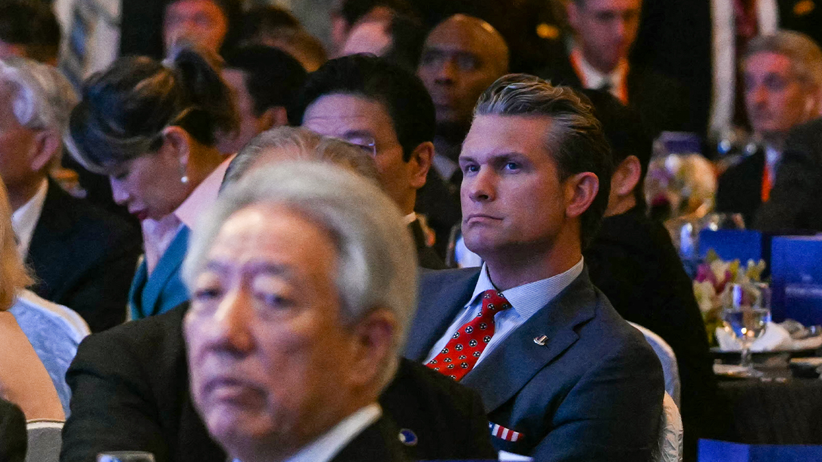US Secretary of Defense Pete Hegseth (R) reacts as France's President Emmanuel Macron gives the keynote address at the Shangri-La Dialogue Summit in Singapore on May 30, 2025.