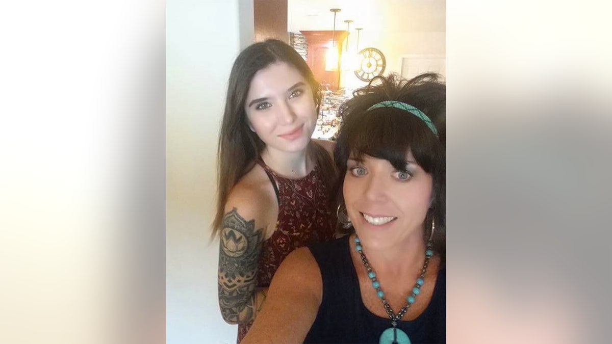 Baylee Despot showing off her arm tattoo behind her mother smiling and taking a selfie.