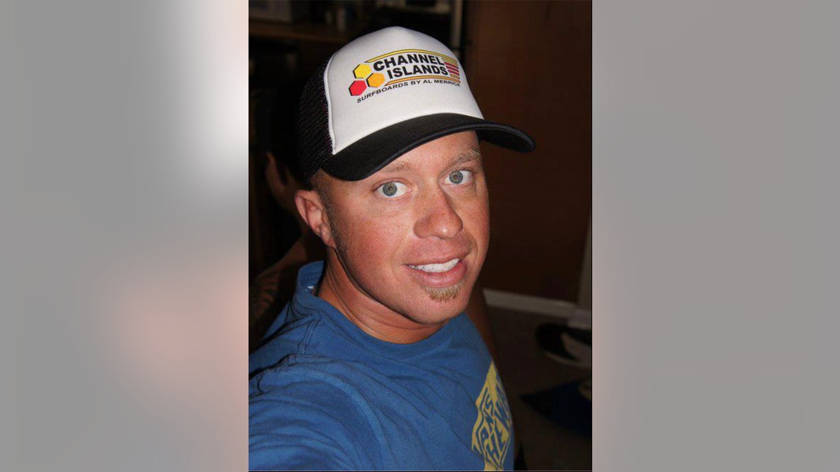 A close-up of James Kulstad wearing a blue shirt with a hat and taking a selfie.