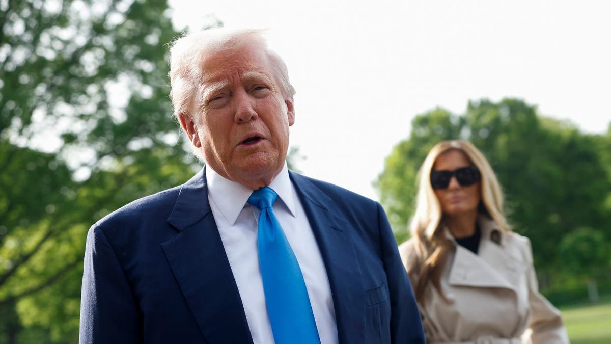 President Donald Trump speaks to the media alongside first lady Melania Trump