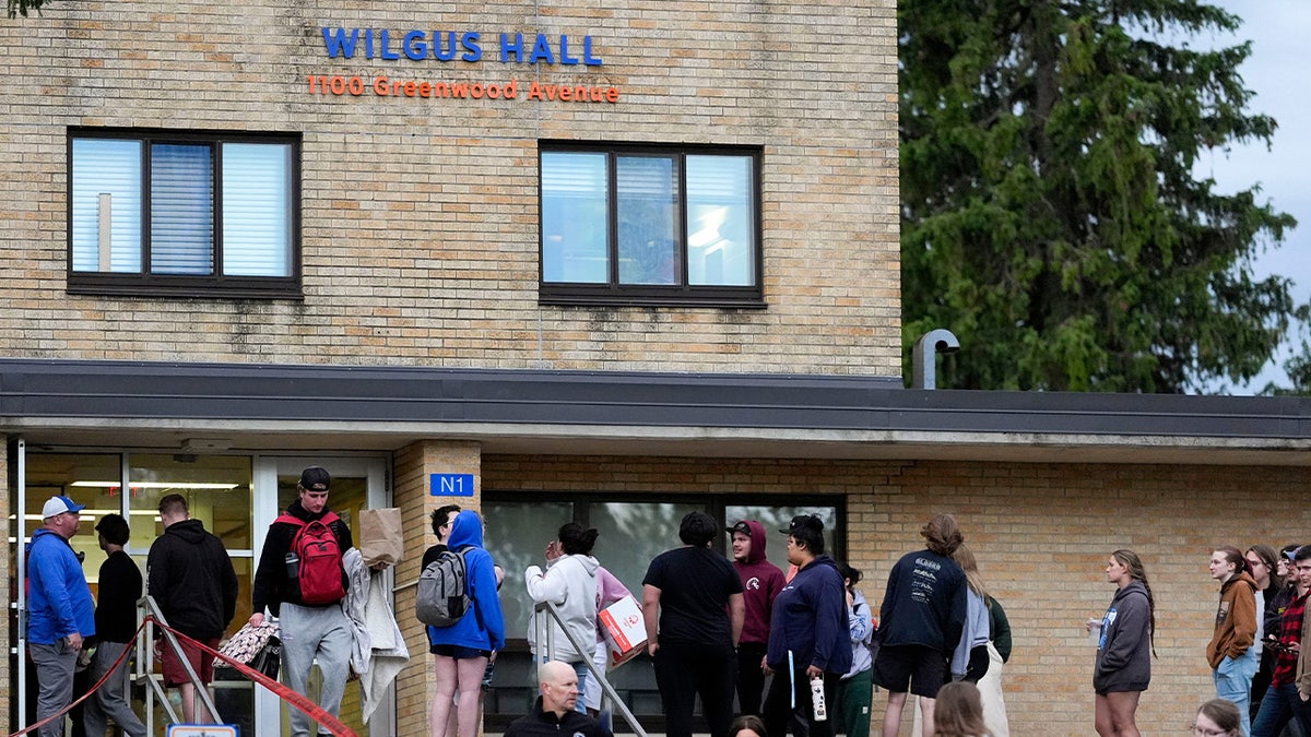 Students wait to be escorted to their dorms to gather their belongings from Wilgus Hall