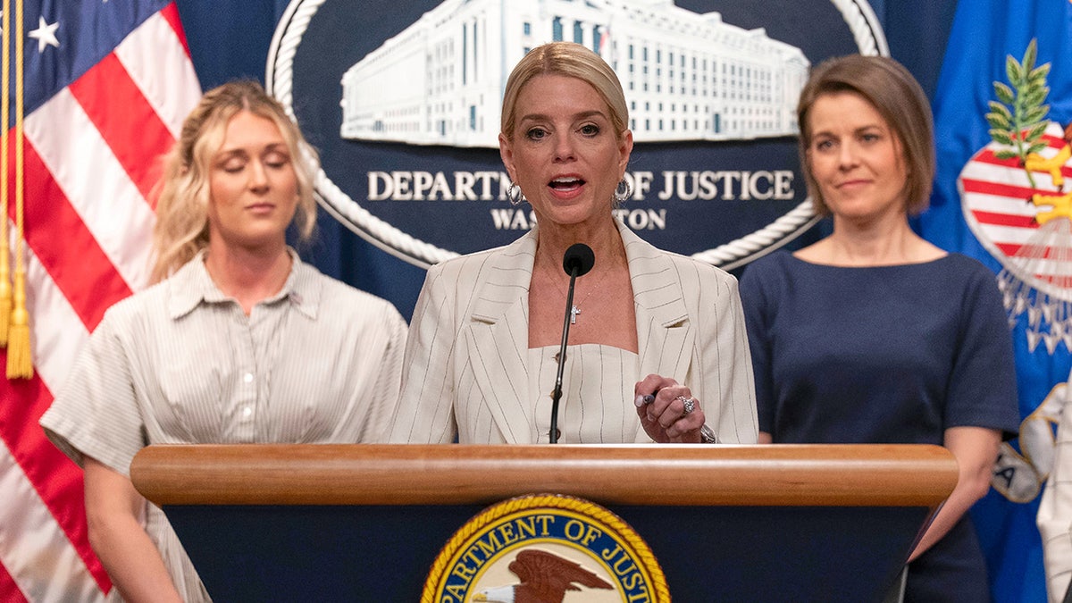 Pam Bondi with others at lectern addressing press
