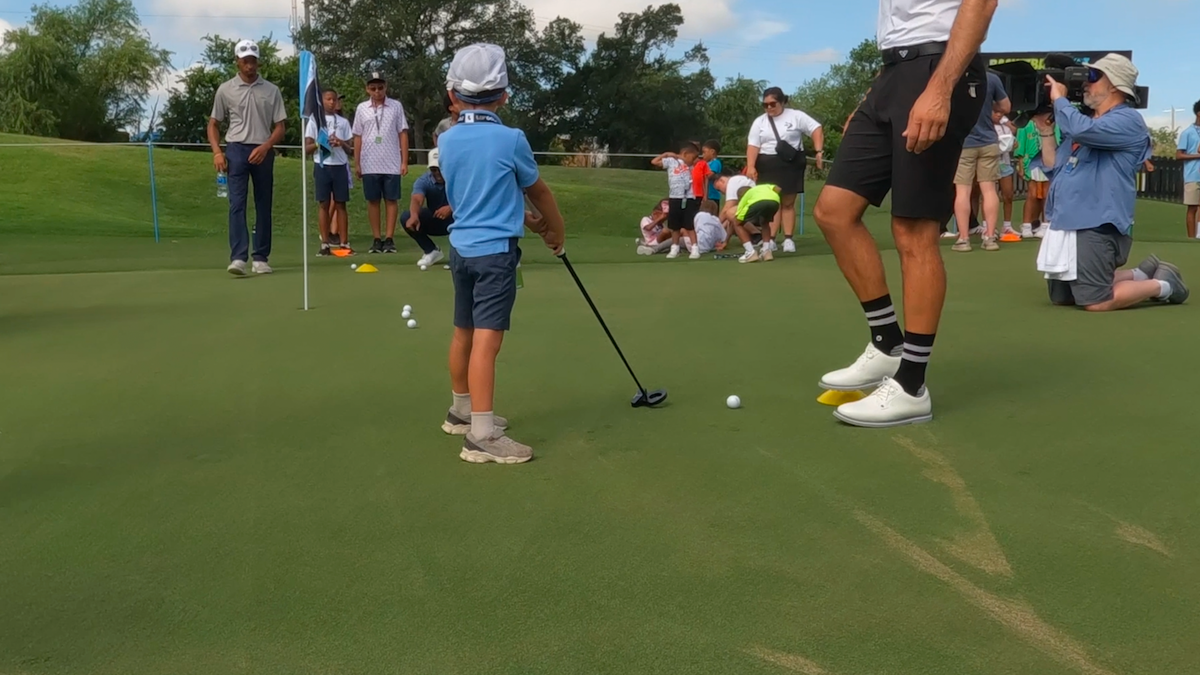 Children practice their golf swing with pros from the HyFlyer GC.