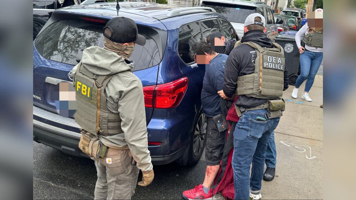 blurred out suspect arrested by car in federal raid