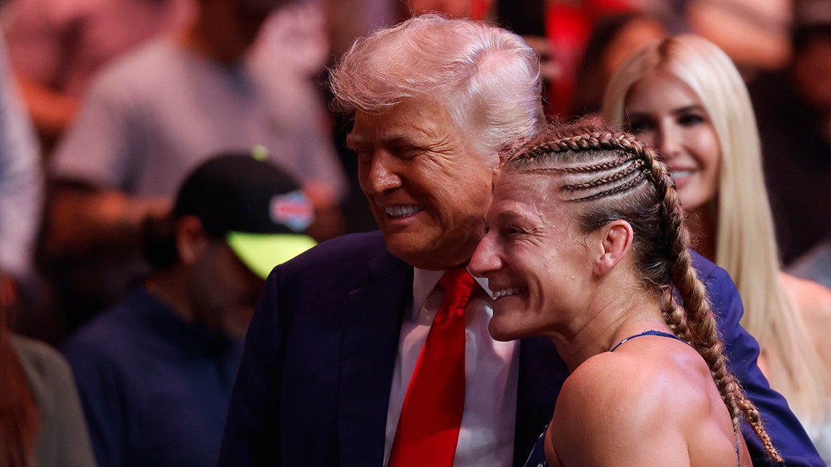 Kayla Harrison poses for a photo with Trump