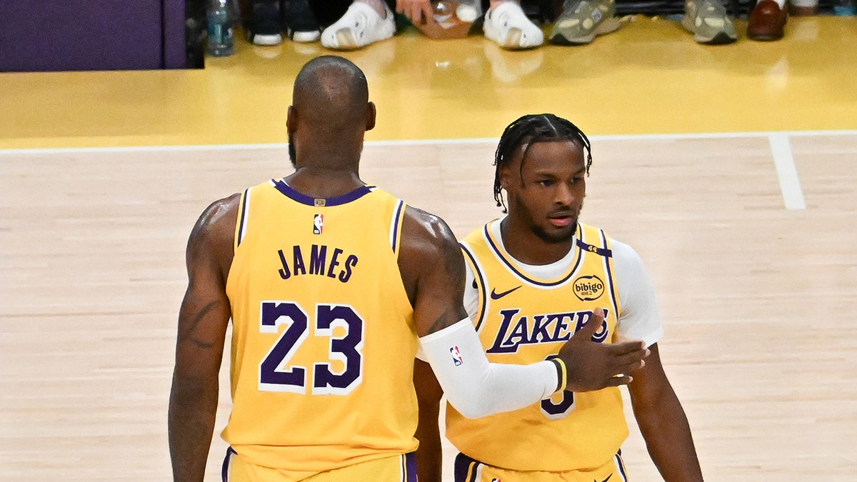 LeBron James, #23, and Bronny James #9 of the Los Angeles Lakers on the court for the first time during the game against the Minnesota Timberwolves at Crypto.com Arena on October 22, 2024, in Los Angeles, California.