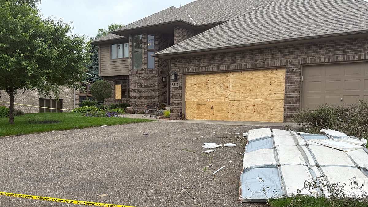 Lawmakers house with garage door torn out and laying in drive way