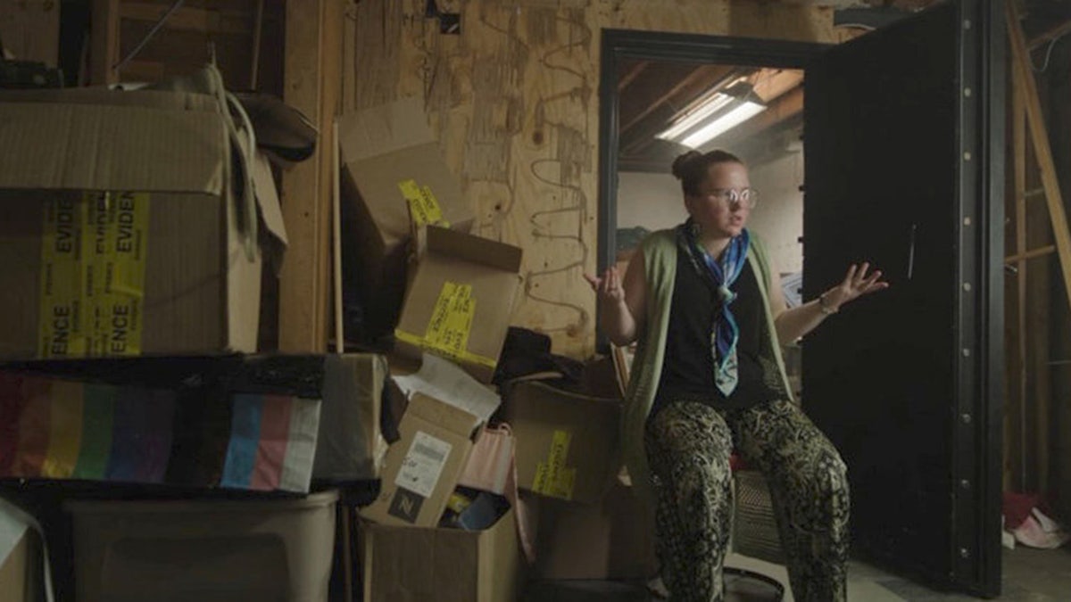 Victoria Heuermann walking near boxes inside her home.