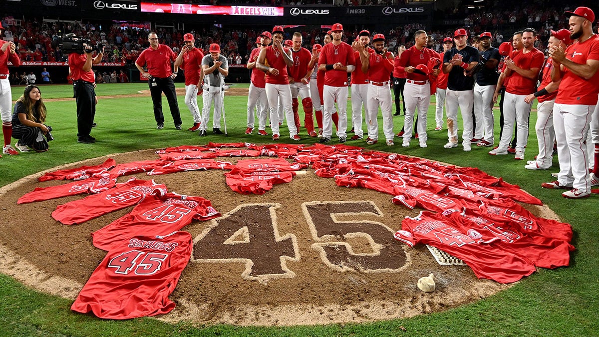 Felix Pena, #45, center, of the Los Angeles Angels looks on after the team placed their jerseys on the mound in honor of Tyler Skaggs as the Los Angeles Angels threw a combined no-hitter and defeated the Seattle Mariners 13-0 during an MLB baseball game at Anaheim Stadium on Friday, July 12, 2019 in Anaheim, California.