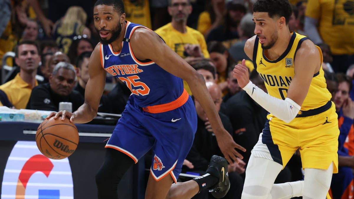 New York Knicks forward Mikal Bridges (25) dribbles the ball defended by Indiana Pacers guard Tyrese Haliburton (0) in the third quarter during game six of the eastern conference finals for the 2025 NBA Playoffs at Gainbridge Fieldhouse. 