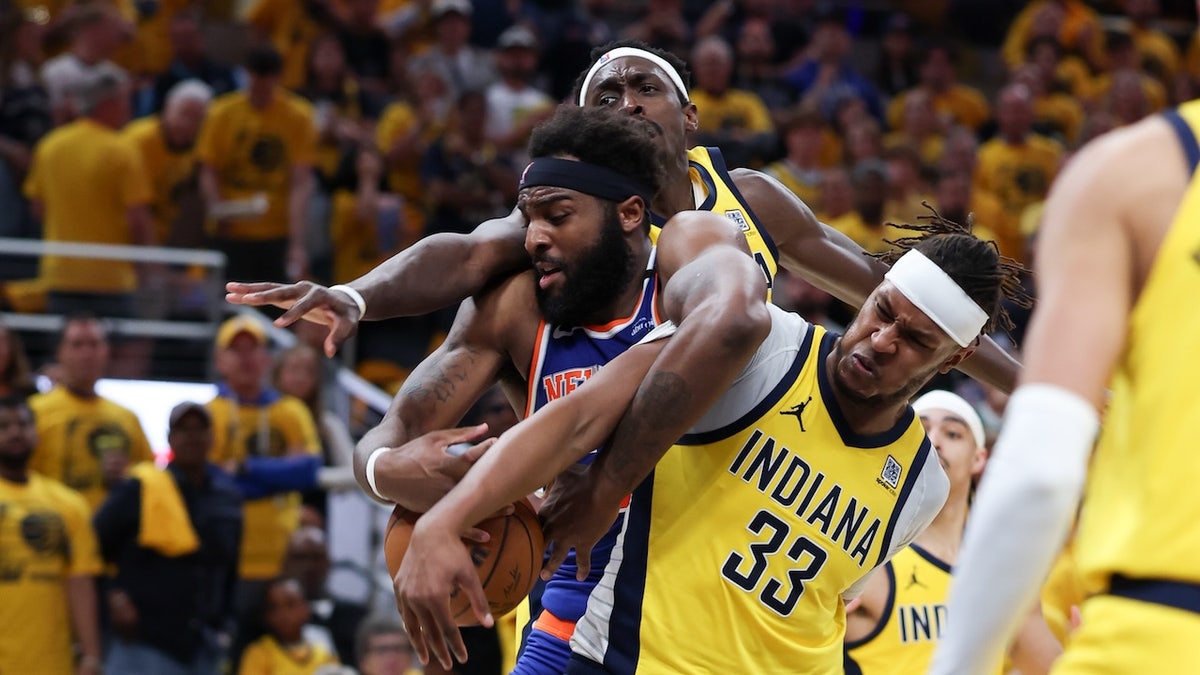 New York Knicks center Mitchell Robinson (23) battles for the ball against Indiana Pacers forward Pascal Siakam (43) and center Myles Turner (33) in the third quarter during game six of the eastern conference finals for the 2025 NBA Playoffs at Gainbridge Fieldhouse. 