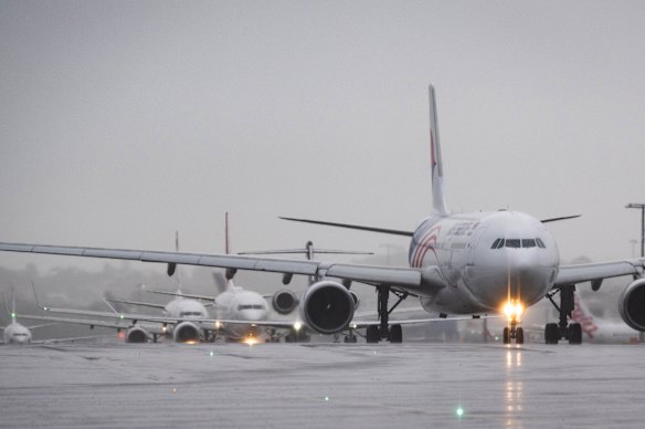 Delayed aircraft line up to take off at Sydney Airport on Tuesday.