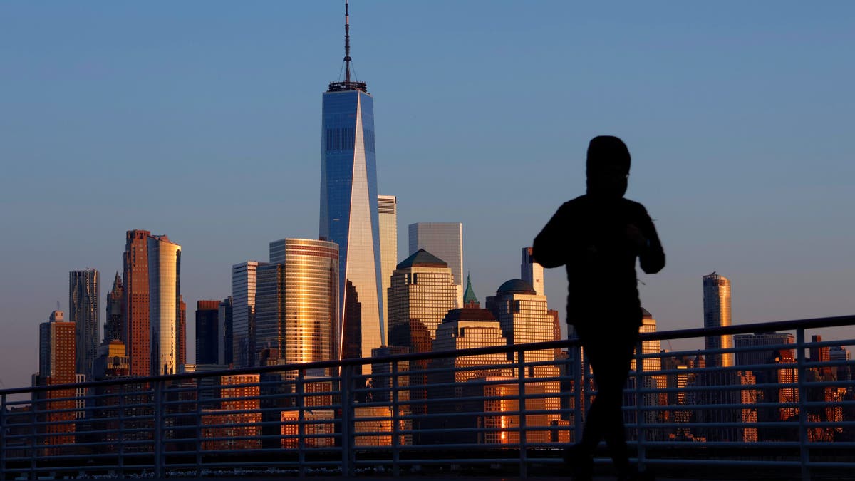 NYC skyline behind a jogger