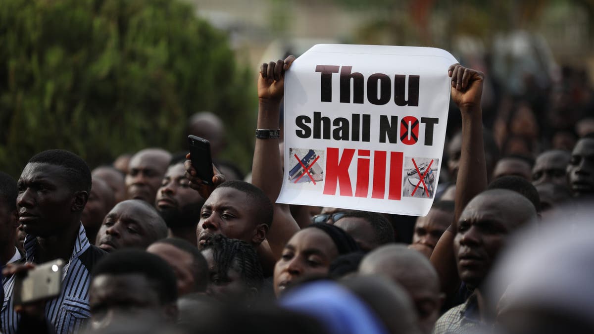 Christian faithfuls hold signs as they march on the streets of Abuja during a prayer and penance for peace and security in Nigeria in Abuja on March 1, 2020.