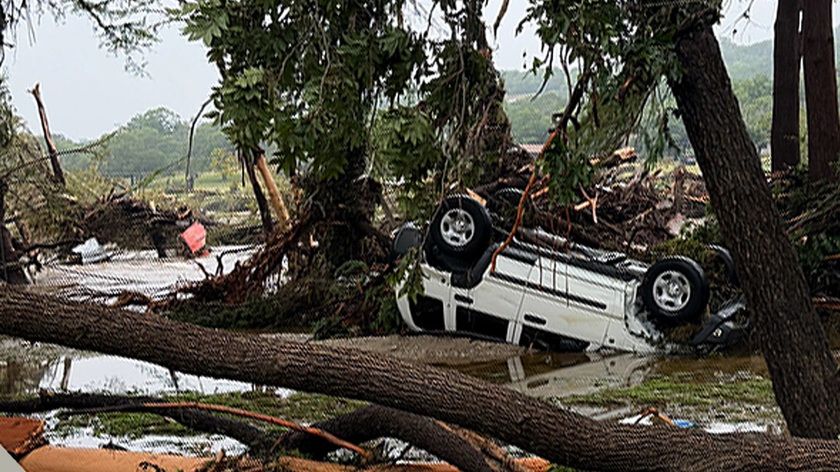 A white car is seen flipped upside down after extensive flooding in Kerrville, Texas.